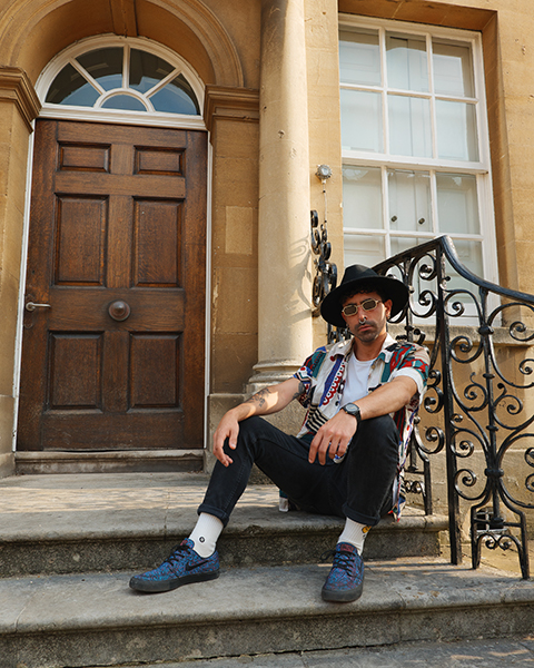 Male model posing sat on steps outside a house in Bristol