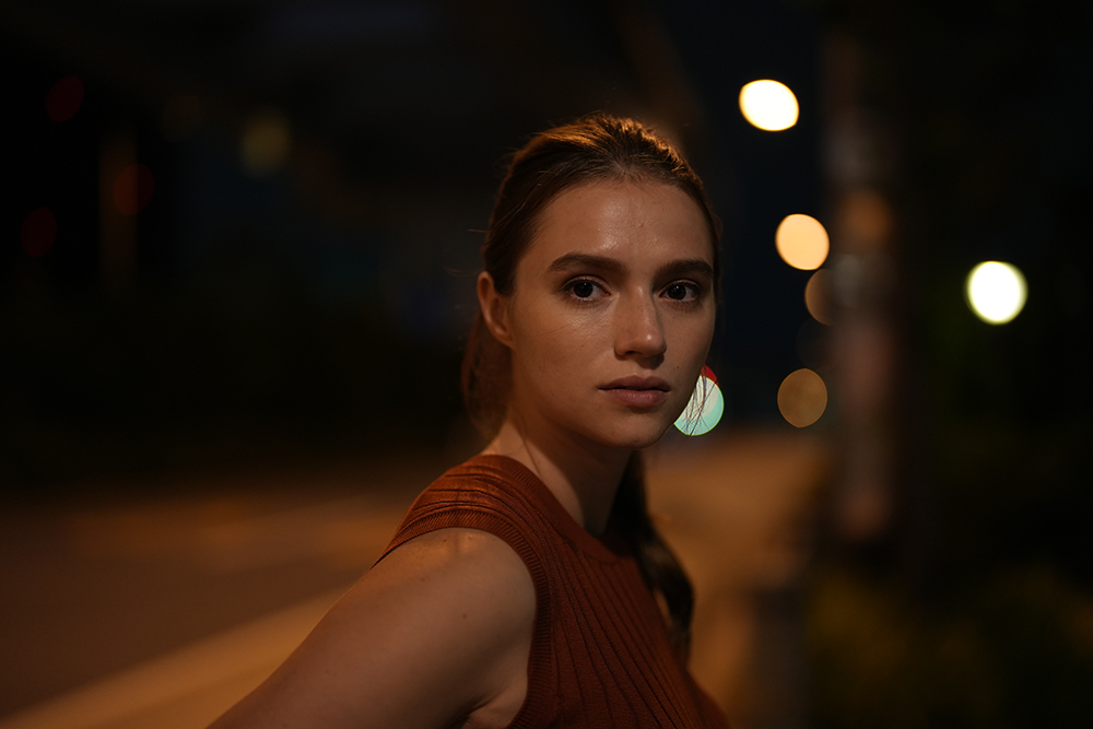 Woman photographed on a street at night taken on Sony a7 IV