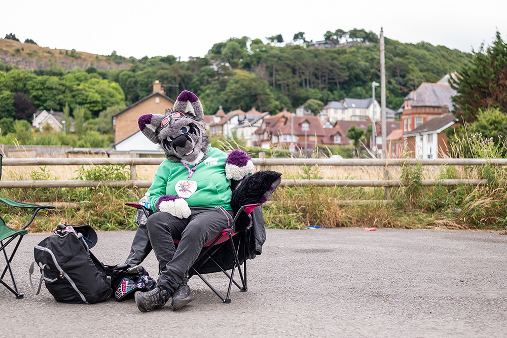 Person in animal costume sat in a camping chair at a festival