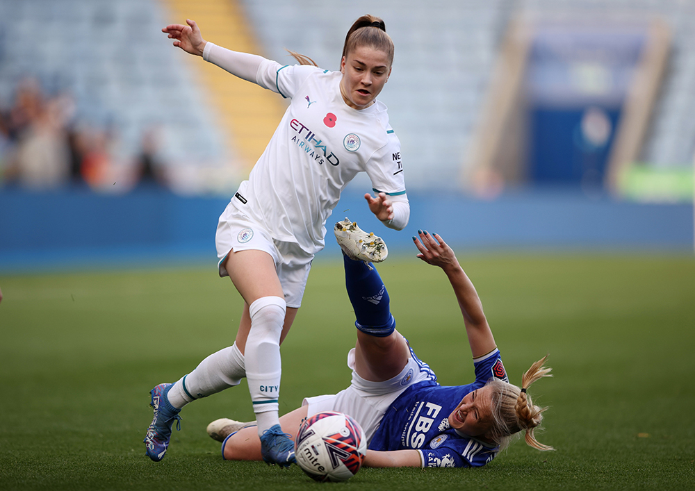 Two female footballers tackling one another