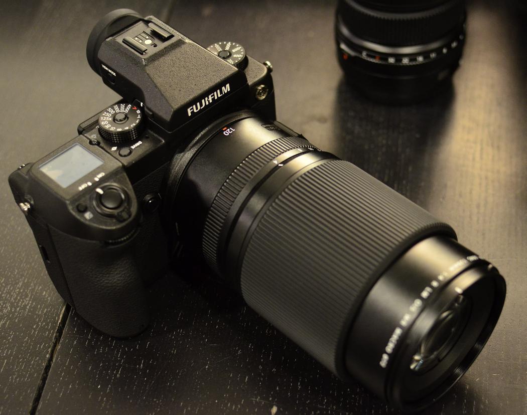 Fuji GFX 50S with a 120mm lens resting on a table.