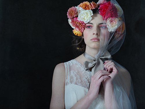 portrait of a young girl with flowers in her hair on a dark background