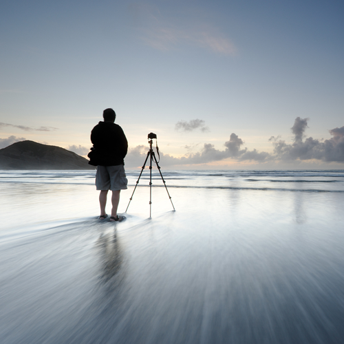 Photographer stood on ice with a mounted ball head tripod