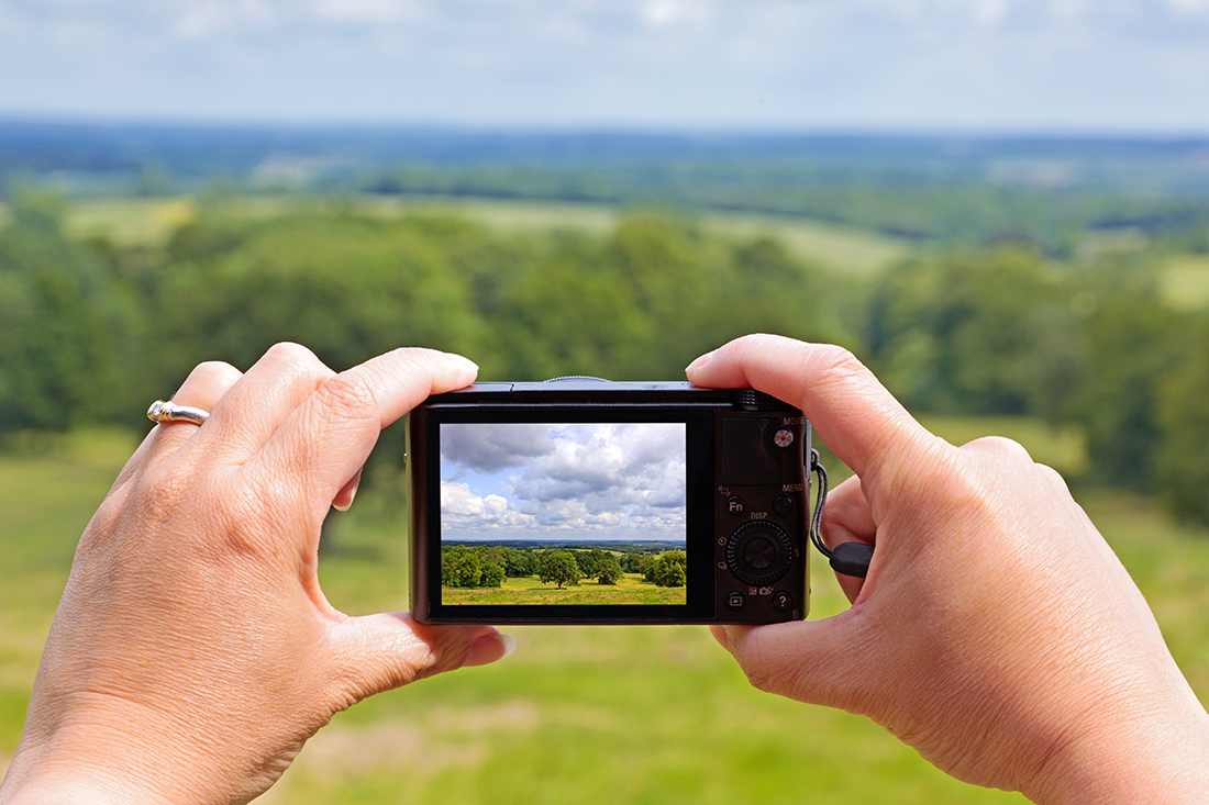 Image of compact camera taking landscape photo