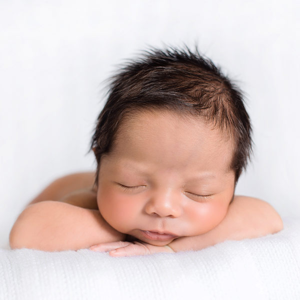 baby with arms crossed on soft blanket