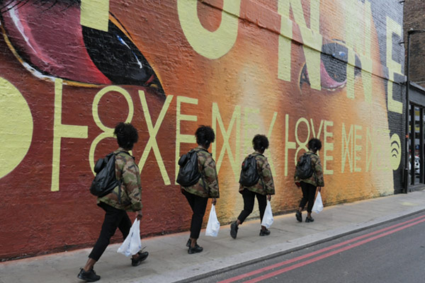 girl walks past graffiti mural in city