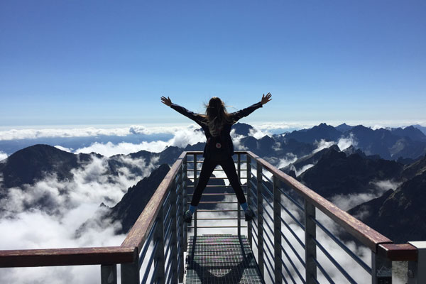 hiking girl poses on top of mountain