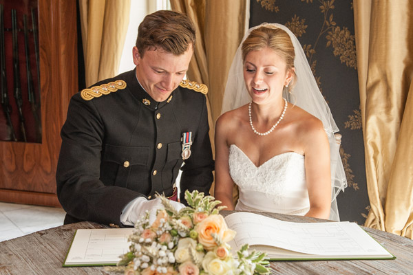 bride and soldier groom sign wedding register