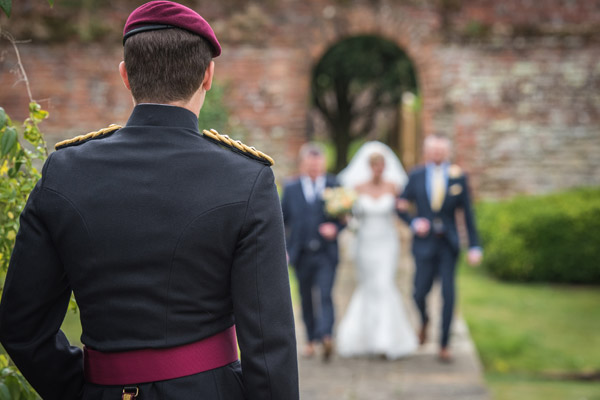 solider awaits his bride at the end of the aisle