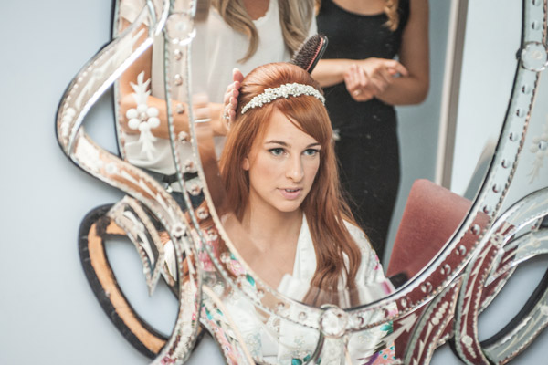 photo of Bride having hair done in reflection of mirror