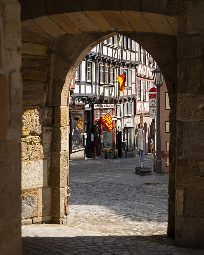 image looking through a tunnel in a city onto a marketsquare